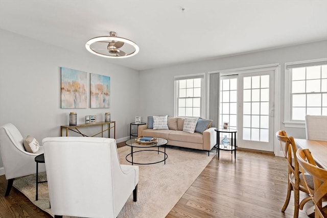 living area with plenty of natural light, wood finished floors, and baseboards
