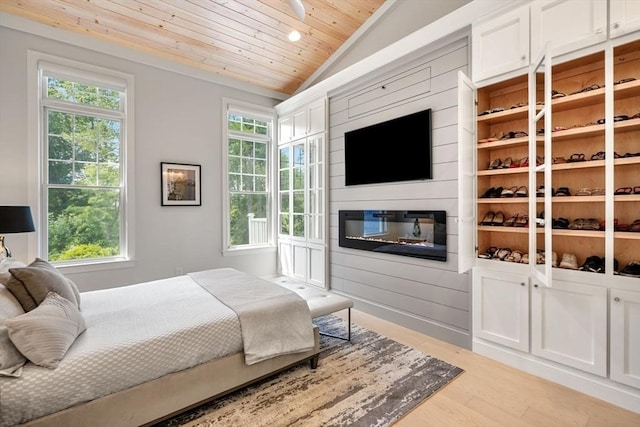 bedroom with multiple windows, lofted ceiling, wood ceiling, and light hardwood / wood-style floors