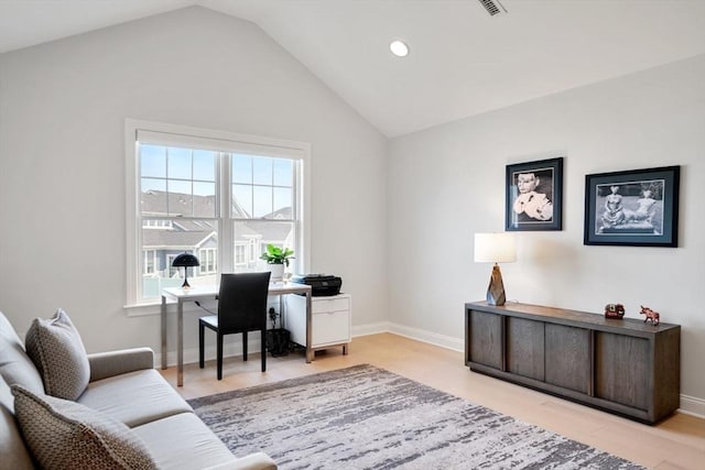 home office with vaulted ceiling and light hardwood / wood-style floors