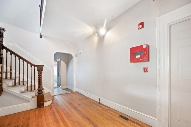 186 Summit St, Pawtucket, RI 02860 - unfurnished room featuring arched walkways, wood-type flooring, stairs, and baseboards