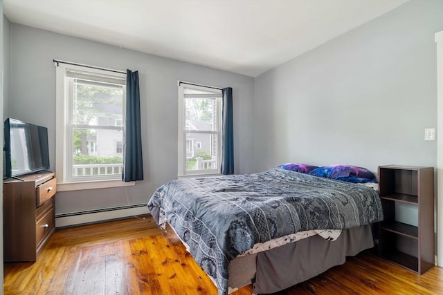 12 Cross St, Pepperell, MA 01463 - bedroom featuring baseboard heating, wood finished floors, and multiple windows