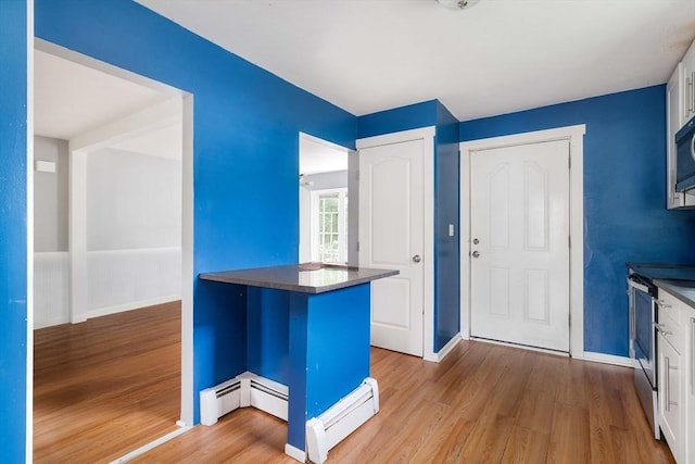 12 Cross St, Pepperell, MA 01463 - kitchen featuring dark countertops, wood finished floors, a baseboard radiator, baseboards, and stainless steel electric range