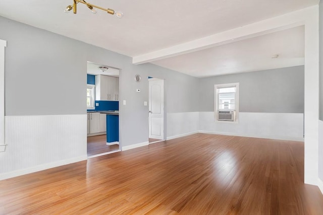 12 Cross St, Pepperell, MA 01463 - unfurnished room featuring a chandelier, a wainscoted wall, light wood-style floors, cooling unit, and beam ceiling