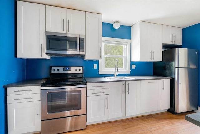12 Cross St, Pepperell, MA 01463 - kitchen with stainless steel appliances, a sink, white cabinetry, and light wood finished floors