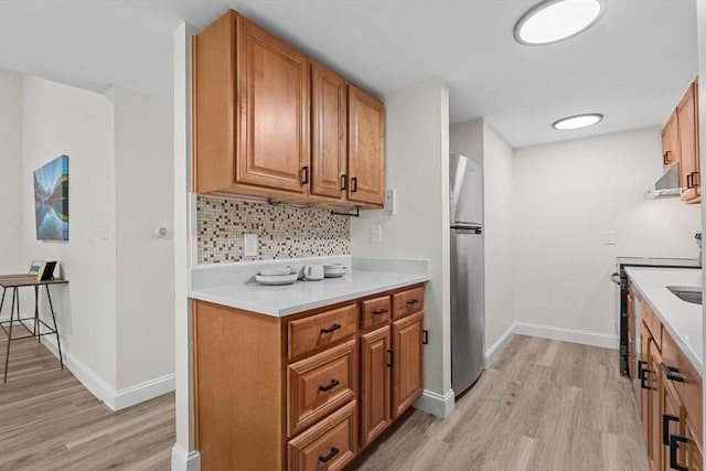 29 Adams Ct Unit 29, Amesbury, MA 01913 - kitchen featuring freestanding refrigerator, wall chimney range hood, light wood-style floors, and decorative backsplash
