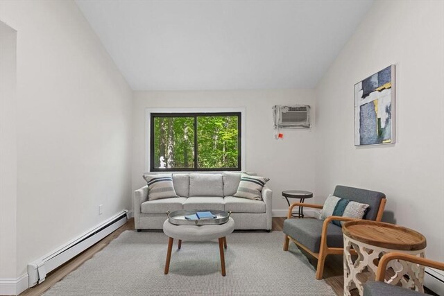 29 Adams Ct Unit 29, Amesbury, MA 01913 - living area featuring a baseboard heating unit, a wall unit AC, wood finished floors, lofted ceiling, and baseboards