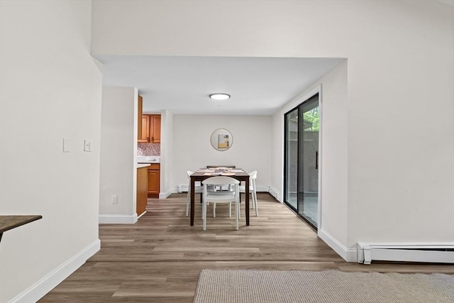 29 Adams Ct Unit 29, Amesbury, MA 01913 - dining room with baseboard heating, baseboards, light wood finished floors, and a baseboard heating unit