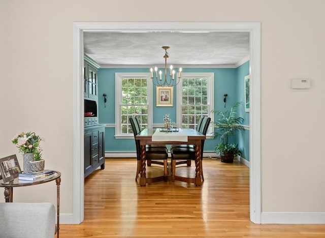1005 Forest St, North Andover, MA 01845 - dining room featuring ornamental molding, a chandelier, light wood-type flooring, baseboards, and a baseboard heating unit
