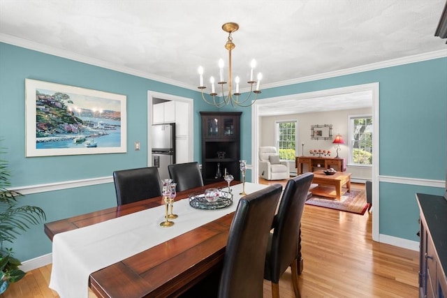 1005 Forest St, North Andover, MA 01845 - dining area with a chandelier, light wood-type flooring, baseboards, and ornamental molding
