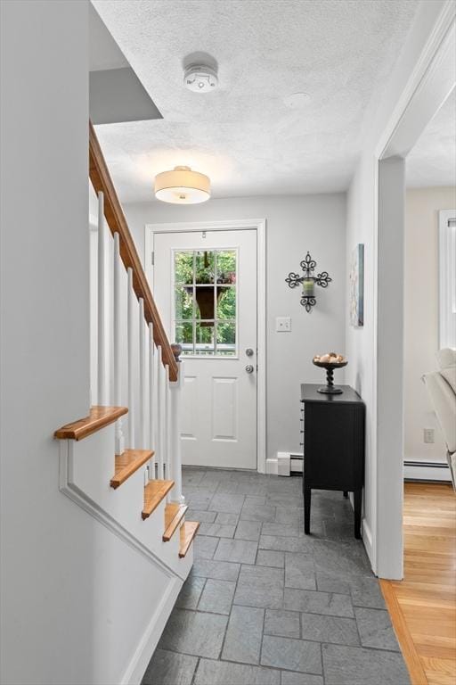 1005 Forest St, North Andover, MA 01845 - foyer with stairway, baseboard heating, a textured ceiling, and a baseboard radiator