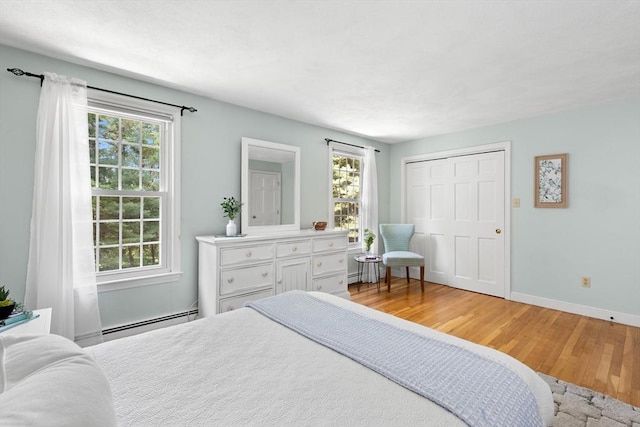1005 Forest St, North Andover, MA 01845 - bedroom with a baseboard heating unit, light wood-type flooring, and baseboards