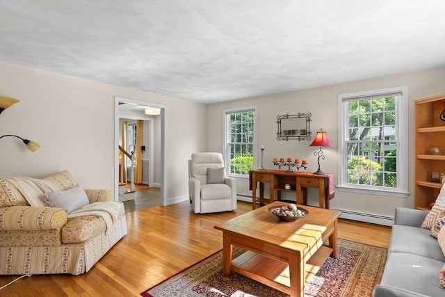 1005 Forest St, North Andover, MA 01845 - living room featuring a baseboard heating unit, healthy amount of natural light, and wood finished floors