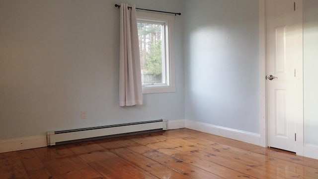 spare room with baseboard heating and hardwood / wood-style floors