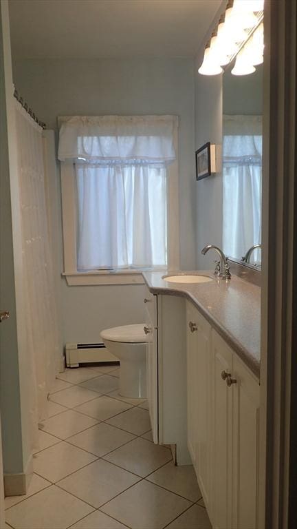 bathroom with tile patterned flooring, a baseboard radiator, a healthy amount of sunlight, and vanity