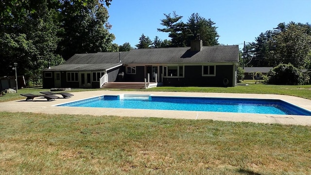 view of pool featuring a lawn