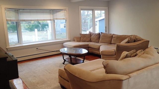 living room featuring a baseboard heating unit and light hardwood / wood-style flooring