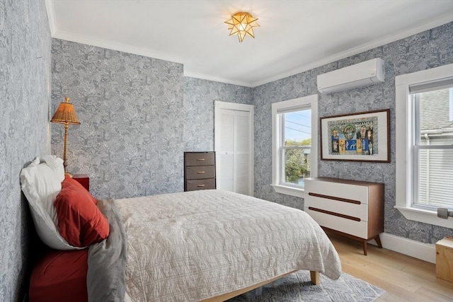 bedroom featuring wood finished floors, wallpapered walls, an AC wall unit, baseboards, and crown molding
