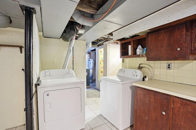 laundry area with light tile patterned flooring and washing machine and clothes dryer