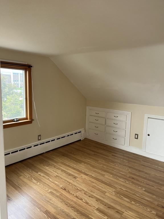 60 Academy Dr, Bourne, MA 02532 - additional living space with a baseboard radiator, vaulted ceiling, light wood-style floors, and baseboards