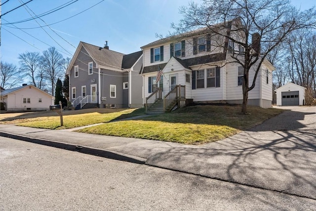 view of front of property featuring an outbuilding, a front lawn, a detached garage, gravel driveway, and a chimney