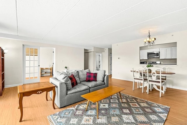 32 Whites Ave Unit F6605, Watertown, MA 02472 - living area with light wood-style floors, a chandelier, and a textured ceiling