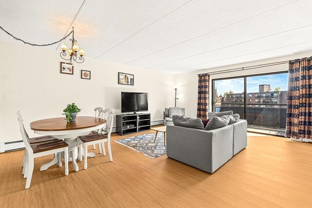 32 Whites Ave Unit F6605, Watertown, MA 02472 - living room featuring light wood finished floors, a chandelier, baseboard heating, and a textured ceiling
