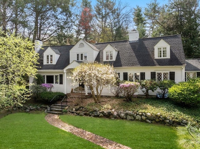 cape cod home with a front lawn, a shingled roof, and a chimney
