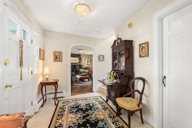 corridor featuring light tile patterned floors, baseboards, and arched walkways