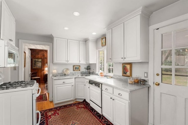 kitchen with white cabinetry, white appliances, and light countertops
