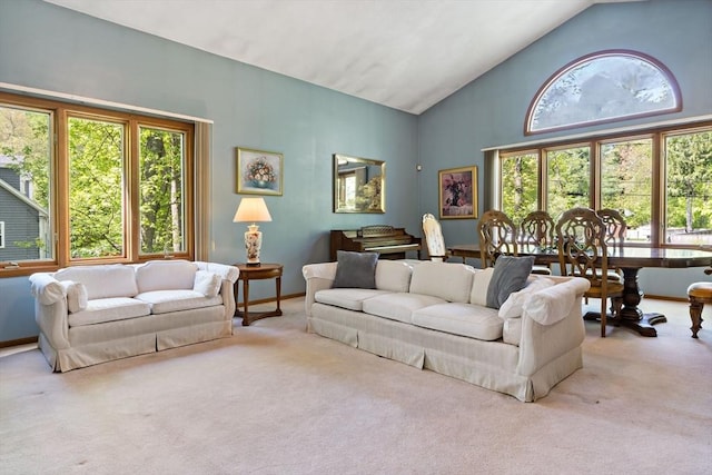 living room featuring plenty of natural light, carpet flooring, high vaulted ceiling, and baseboards