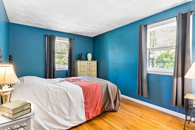 bedroom with baseboards and wood finished floors
