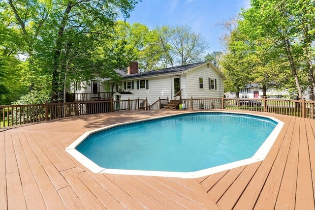 outdoor pool featuring a wooden deck and entry steps