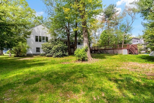 view of grassy yard with a wooden deck and stairway