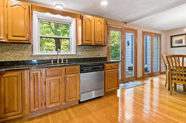 kitchen featuring dishwasher, backsplash, light wood-style floors, brown cabinets, and beamed ceiling