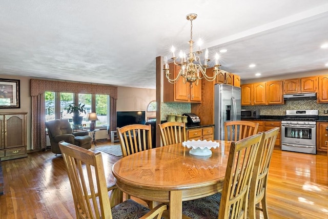 dining room with light wood-type flooring, a chandelier, and recessed lighting