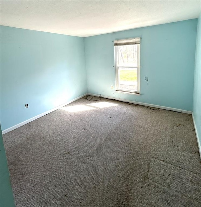 empty room with baseboards and carpet