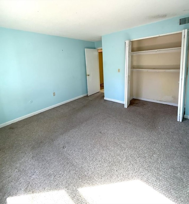 unfurnished bedroom with a closet, baseboards, carpet flooring, and visible vents