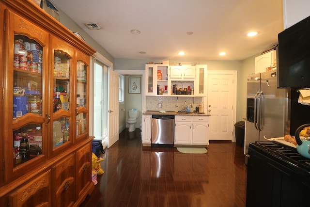 kitchen featuring appliances with stainless steel finishes, dark hardwood / wood-style flooring, decorative backsplash, and white cabinetry