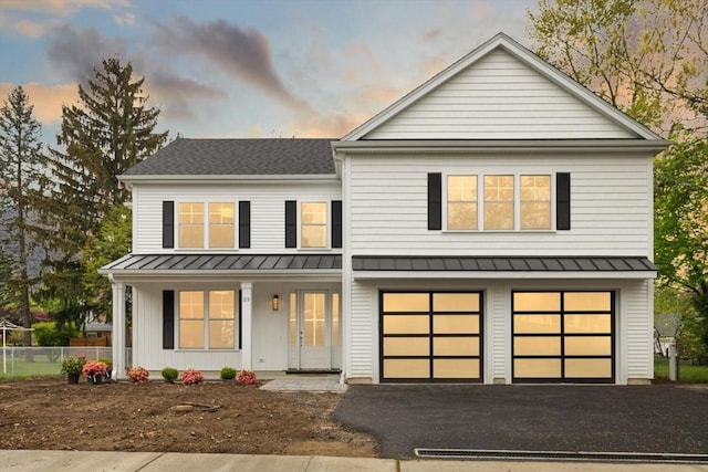 23 Sylvester Rd, Newton, MA 02465 - view of front facade with a standing seam roof, covered porch, a garage, driveway, and metal roof