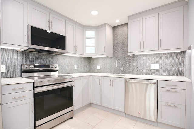 kitchen with stainless steel appliances, white cabinetry, and sink