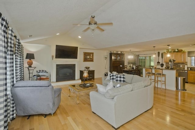 717 Northampton St Unit 41, Holyoke, MA 01040 - living area featuring light wood-style flooring, a ceiling fan, a fireplace with raised hearth, and high vaulted ceiling