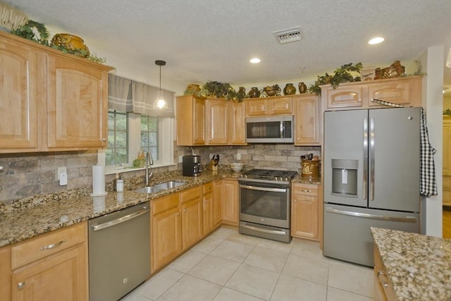 717 Northampton St Unit 41, Holyoke, MA 01040 - kitchen with stainless steel appliances, backsplash, light stone countertops, light tile patterned floors, and hanging light fixtures