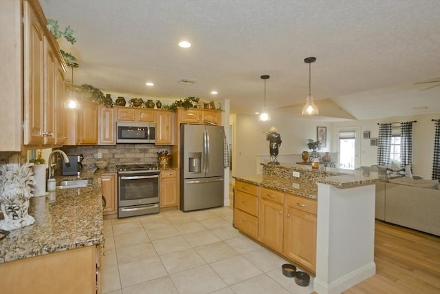 717 Northampton St Unit 41, Holyoke, MA 01040 - kitchen with appliances with stainless steel finishes, open floor plan, decorative backsplash, light stone counters, and hanging light fixtures