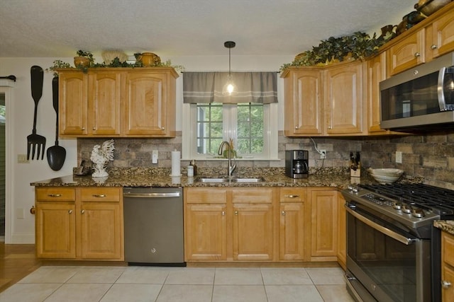 717 Northampton St Unit 41, Holyoke, MA 01040 - kitchen with stainless steel appliances, dark stone countertops, backsplash, a textured ceiling, and light tile patterned flooring