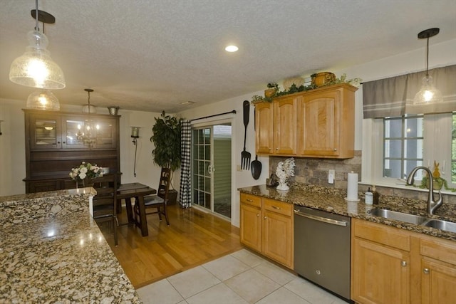 717 Northampton St Unit 41, Holyoke, MA 01040 - kitchen with dishwasher, a textured ceiling, dark stone countertops, light tile patterned floors, and decorative backsplash