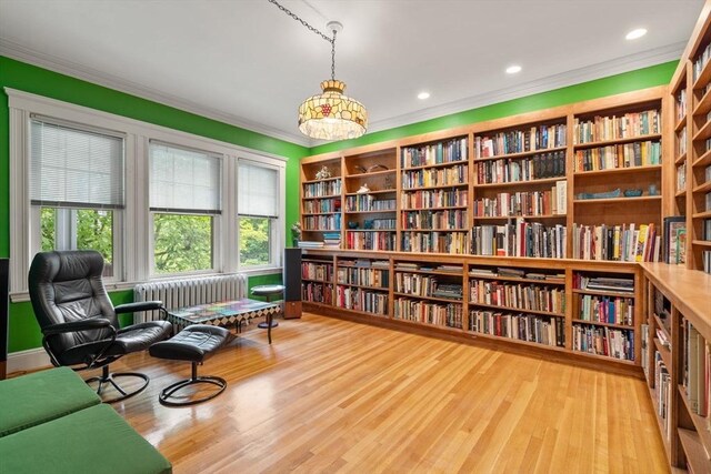 97 Stearns Rd, Brookline, MA 02446 - living area featuring wall of books, radiator, ornamental molding, wood finished floors, and recessed lighting