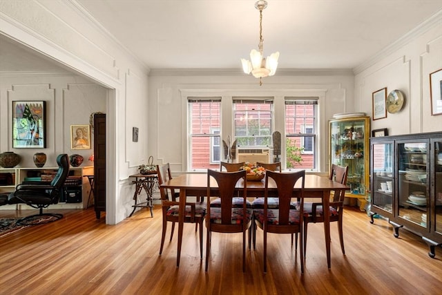 97 Stearns Rd, Brookline, MA 02446 - dining area featuring light wood-style flooring, crown molding, a chandelier, and a decorative wall