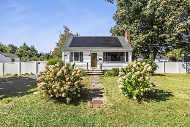 view of front facade with a front yard and solar panels