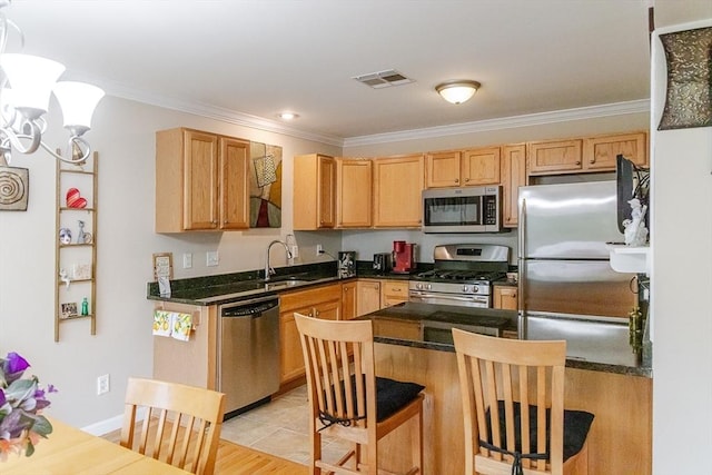 kitchen featuring crown molding, a sink, a kitchen breakfast bar, stainless steel appliances, and visible vents