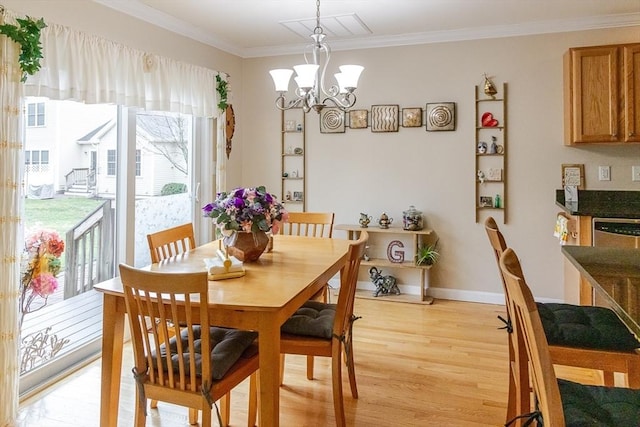 dining space featuring crown molding, baseboards, an inviting chandelier, and light wood-style flooring